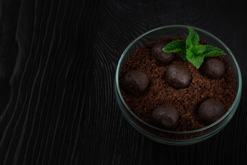 Chocolate dessert of cookies with pieces of chocolate and mint on a dark wooden background with copyspace, food and drink concept