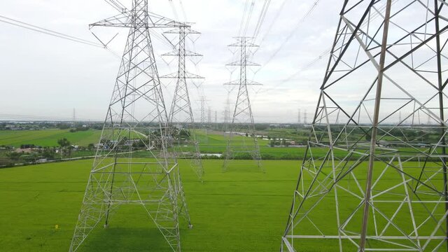 Aerial view drone shot. High voltage metal post. High-voltage towers in the field with moving sky and clouds background. footage video