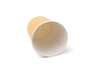 An empty disposable paper cup for coffee, already used, lying like garbage. Isolated on a white background with a shadow