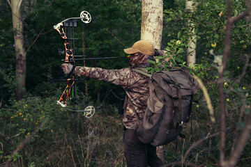 Archery hunter with his bow drawn back ready for a shot