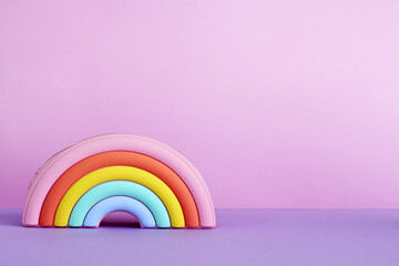 handbag in the form of a bright rainbow on a lilac background