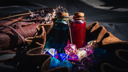 A romantic image of a dice bag, notebook, and potion bottles in the sun