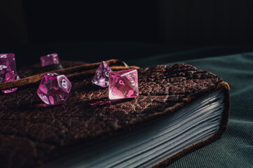 Close-up image of role-playing gaming dice on top of a leather-bound book