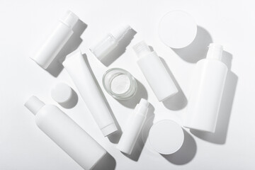 A set of cosmetic products in white tubes with empty space for labeling. Cosmetics for face and body skin care. Moisturizing cream, purifying mask.