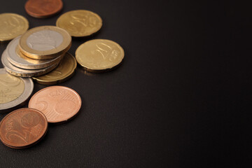 Euro and euro cent coins on a black table