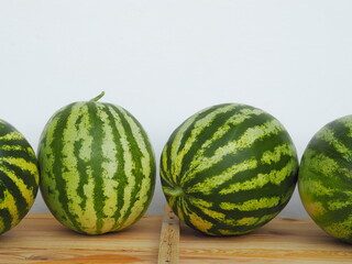 Large fruits of watermelons on a wooden table. Food background.