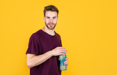 young guy with unshaven face and stylish hair drink water, sport