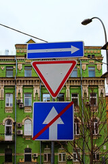 Traffic signs in the city. One way street in direction of right arrow road sign, give way priority...