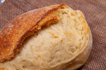 close-up part of a whole loaf of bread on sacking background