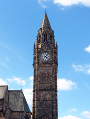 Fototapeta na wymiar the tall clock tower of historic 19th century rochdale town hall in lancashire with blue summer sky and white clouds