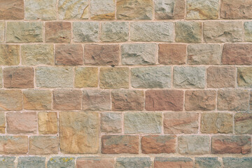 Sandstone wall with red, yellow and gray stones