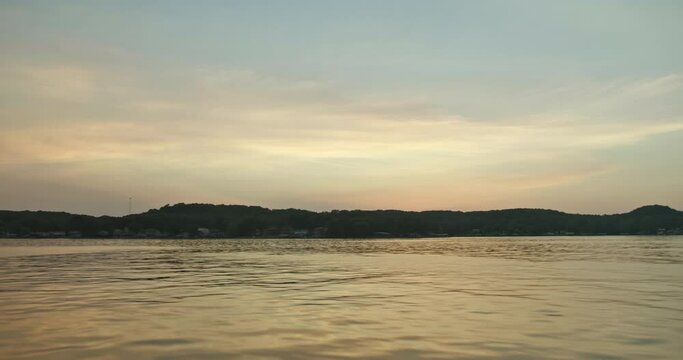 Sunset over lake boating towards house shore