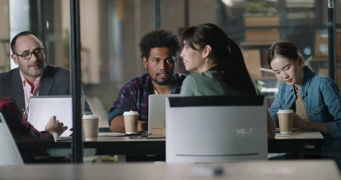 Millennial hipster employees discussing marketing strategies with diverse multiethnic team on brainstorming session in office. Creative workers on workshop 4k footage
