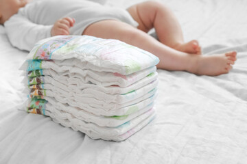Stack of diapers on a white bed