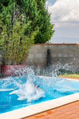 huge splash of water is created by a cannonball dive into a swimming pool