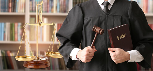 Male judge with gavel and scales of justice in library