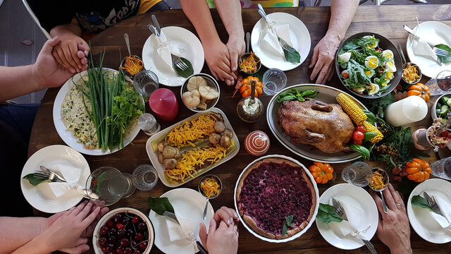 Thanksgiving Dinner With The Family. Children , Grandchildren Of Grandparents Hold Each Other's Hands. Prayer.