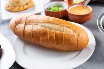 A view of a pre-sliced dinner roll on a plate.
