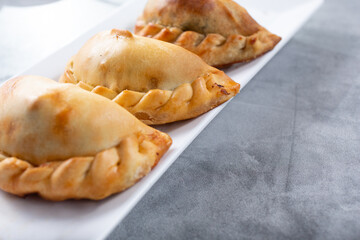 A view of three empanadas on a plate.