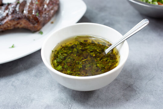 A View Of A Dish Of Chimichurri Sauce, Next To A Skirt Steak. 