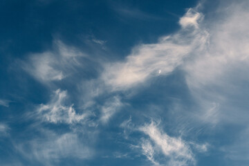 blue sky with clouds and crescent moon
