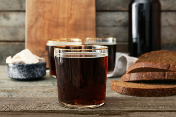 Glass of fresh kvass on wooden background