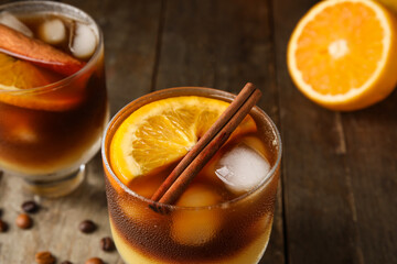 Glasses of tasty coffee with orange juice on wooden background, closeup