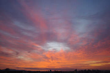 兵庫県神戸市東灘区の高層マンションの上層階からの夜明け。大阪生駒山から太陽が昇り、あたりはオレンジ色に染まり、ビル群がシルエットで浮かぶ
