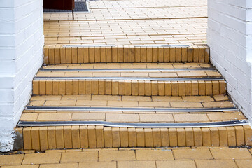 steps with rubber non-slip strips on the arch staircase at the entrance to the white brick building close-up, nobody.
