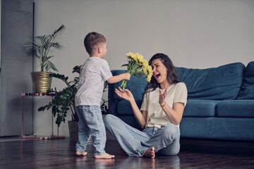 Happy mother day. child son congratulates mother on holiday and gives flowers. congratulating her...