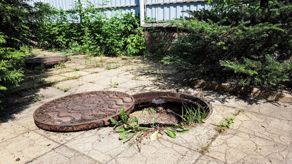 A hose is lowered into the sewer manhole to pump water out of the pit. cleaning of the sewer pit. maintenance and care in a private home. summer