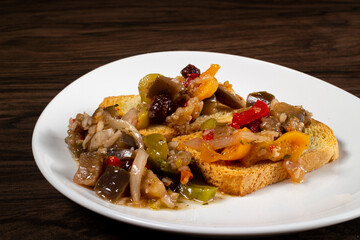 Eggplant appetizer antipasti made with yellow pepper, onion, raisin, and olive oil