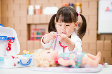 young girl pretend play doctor role  at home