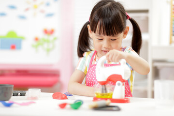 young  girl pretend play food preparing at home