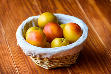 Mirabelle Plums in a basket on a wooden table