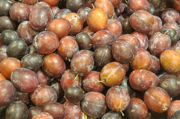 Lots of fresh ripe plums in market fruit and vegetable section. Good fruits with lots of vitamins, fibers and other good health benefits and ingredients. 
