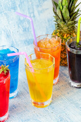 Refreshing frozens in various fruits and colors on a blue background.