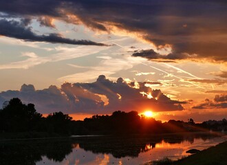 Fototapeta premium Beautiful colorful sunset with dramatic sky on the lake