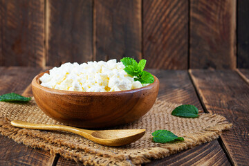 Bowl of cottage cheese on wooden background. Fresh homemade cottage cheese