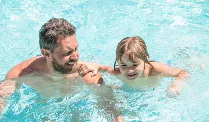 happy family of father and small boy having fun in summer swimming pool, resort