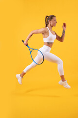 Fototapeta na wymiar happy tennis player running with racket on yellow background, badminton