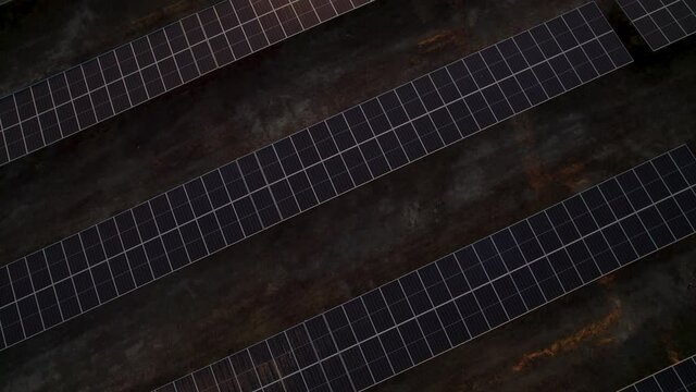 Massive solar plant at sunset. Hundreds of moving solar panels to provide clean energy. Talasol. Drone going forwards and tilting up, revealing the solar plant.