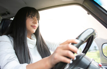 Fototapeta na wymiar Hispanic woman driving the vehicle, city driver concept