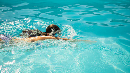 Woman swimming in a pool with swimming goggles