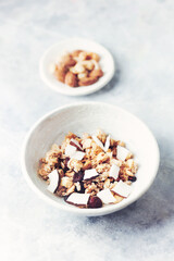 Bowl of granola with nuts, cranberry and cocoanut. Concept for a tasty and healthy meal. Stone background. Close up.	