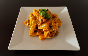 Tomato cannelloni pasta on white squared dish