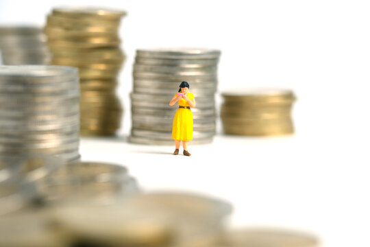 Miniature people toy figure photography. A men student standing the middle of money coin stack, isolated on white background