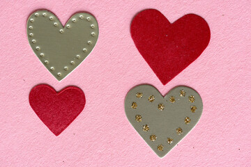 four paper hearts on pink