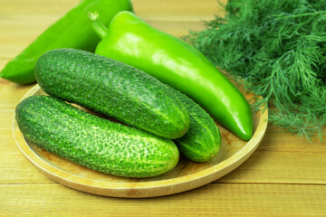 Fresh cucumbers, long sweet green pepper and dill on wooden table. Green vitamin vegetables. Healthy food.