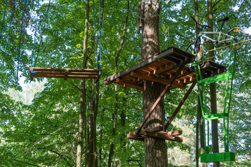 Bike on a rope with a shifted center of gravity for balance. Obstacle course in rope park at height in the foliage of the trees. Outdoor activities. Adventure among  foliage of trees in the forest. 
